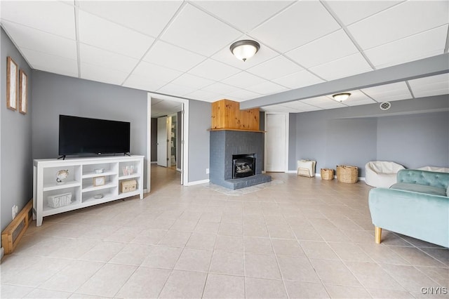 3477 Mcclary Rd, Lafayette, NY 13084 - living area featuring baseboards, light tile patterned floors, a drop ceiling, and a brick fireplace