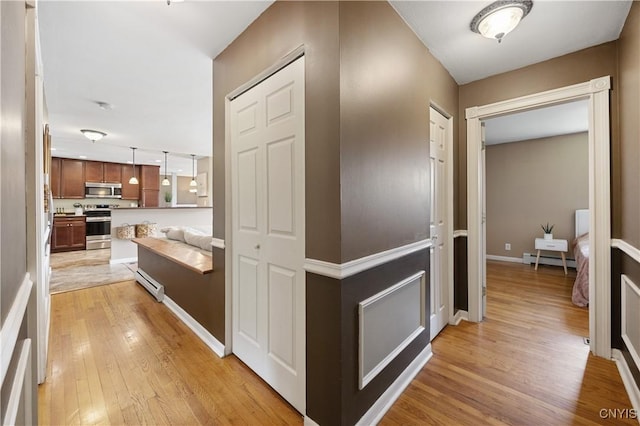3477 Mcclary Rd, Lafayette, NY 13084 - hallway featuring baseboard heating, light wood-type flooring, and baseboards