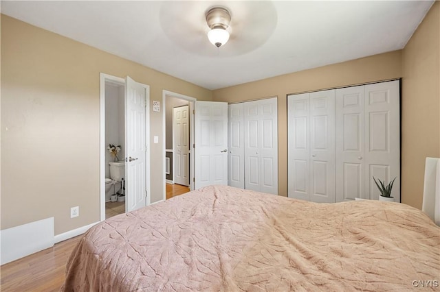 3477 Mcclary Rd, Lafayette, NY 13084 - bedroom featuring multiple closets, wood finished floors, baseboards, ensuite bathroom, and ceiling fan
