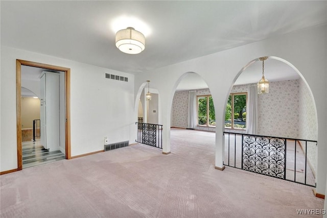 61 Caesar Blvd, Amherst, NY 14221 - empty room with arched walkways, carpet floors, baseboards, and wallpapered walls