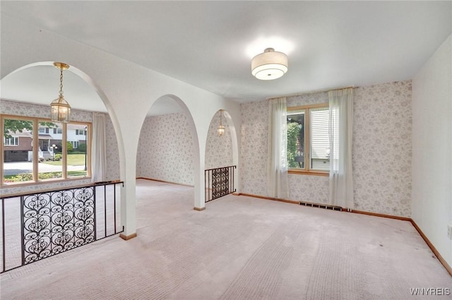 61 Caesar Blvd, Amherst, NY 14221 - empty room with wallpapered walls, carpet, baseboards, and arched walkways