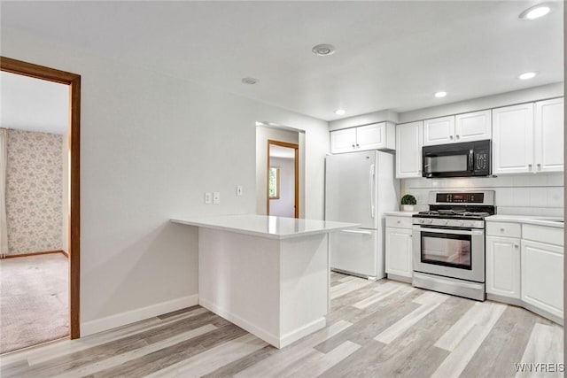 61 Caesar Blvd, Amherst, NY 14221 - kitchen featuring stainless steel range with gas stovetop, black microwave, freestanding refrigerator, light countertops, and light wood-type flooring