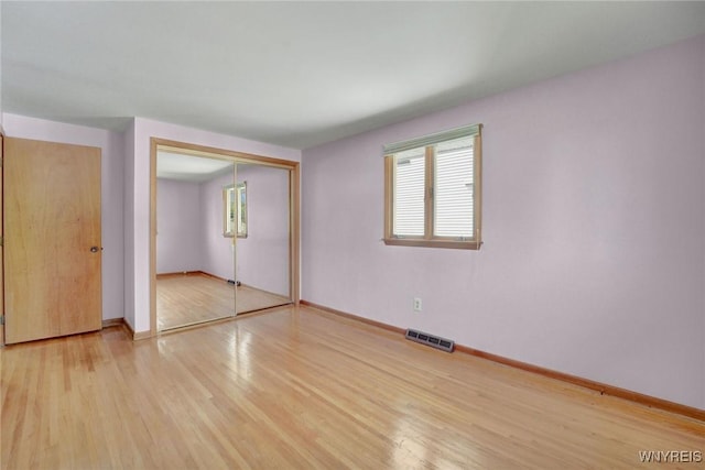 61 Caesar Blvd, Amherst, NY 14221 - unfurnished bedroom featuring multiple windows, wood finished floors, a closet, and baseboards