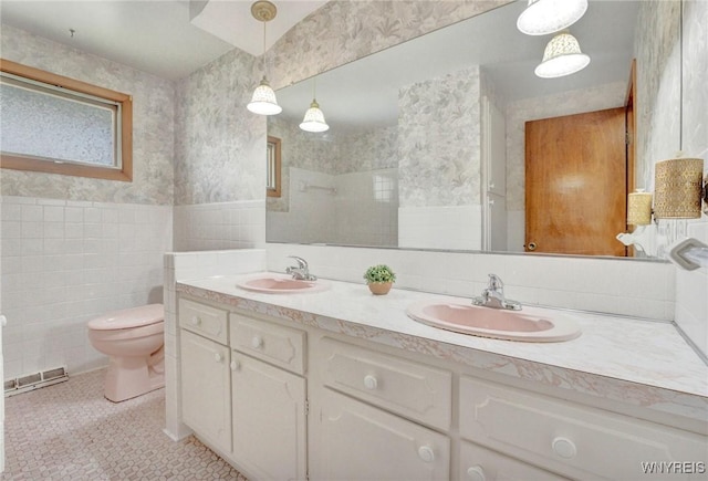 61 Caesar Blvd, Amherst, NY 14221 - full bath with tile walls, double vanity, toilet, wallpapered walls, and tile patterned flooring