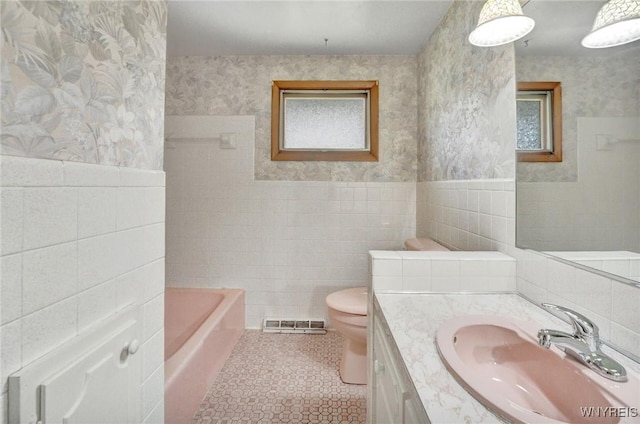 61 Caesar Blvd, Amherst, NY 14221 - bathroom featuring tile walls, vanity, toilet, and tile patterned flooring
