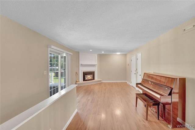 61 Caesar Blvd, Amherst, NY 14221 - living area with a textured ceiling, light wood finished floors, baseboards, a large fireplace, and recessed lighting