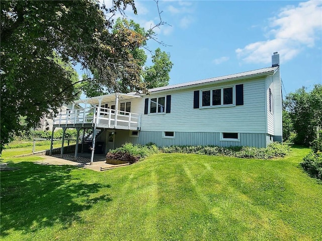 6251 Willard St, Aurelius, NY 13034 - rear view of house featuring a chimney, a lawn, a wooden deck, and metal roof