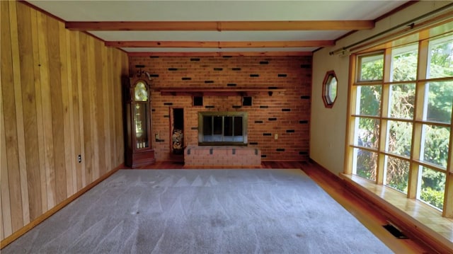 6251 Willard St, Aurelius, NY 13034 - unfurnished living room with beam ceiling, wood walls, a fireplace, and wood finished floors