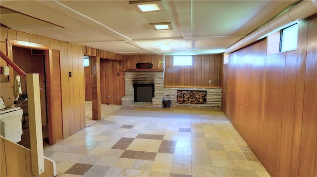 6251 Willard St, Aurelius, NY 13034 - unfurnished living room with light floors, a stone fireplace, and wood walls