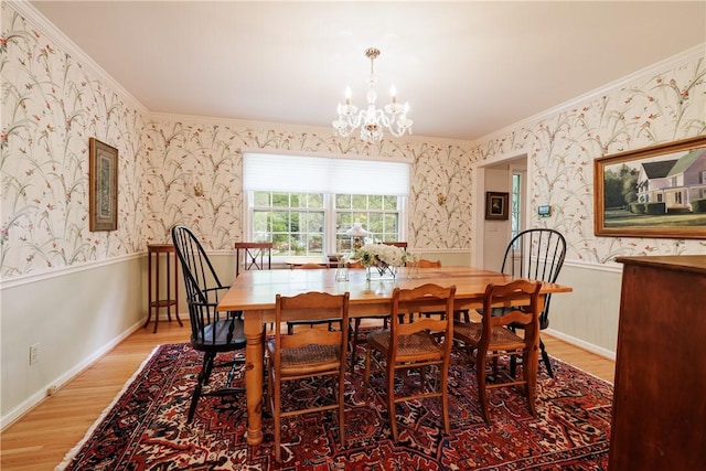 307 Allens Creek Rd, Brighton, NY 14618 - dining area featuring ornamental molding, light wood-style flooring, a chandelier, wallpapered walls, and a wainscoted wall