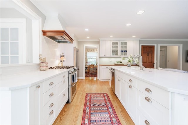 307 Allens Creek Rd, Brighton, NY 14618 - kitchen featuring stainless steel appliances, a sink, custom range hood, crown molding, and light wood-style floors