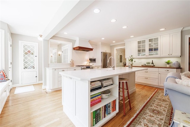 307 Allens Creek Rd, Brighton, NY 14618 - kitchen featuring premium range hood, stainless steel appliances, a kitchen bar, a sink, and glass insert cabinets