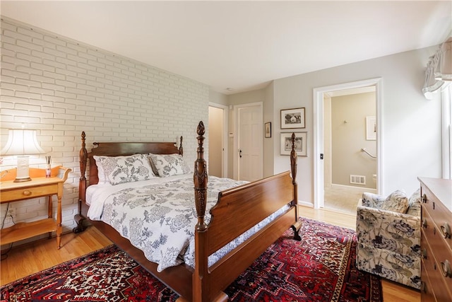 307 Allens Creek Rd, Brighton, NY 14618 - bedroom featuring light wood-type flooring and brick wall