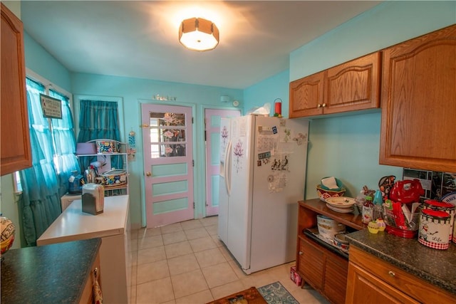 249 Glasgow St, Galen, NY 14433 - kitchen with white refrigerator with ice dispenser, light tile patterned flooring, brown cabinets, and dark countertops