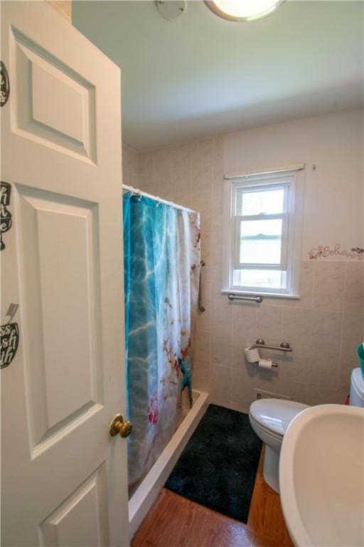 249 Glasgow St, Galen, NY 14433 - bathroom with toilet, a shower stall, wood finished floors, tile walls, and a sink