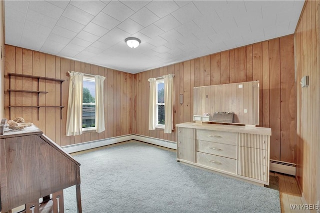 65 E Main St, Arcade, NY 14009 - unfurnished bedroom featuring a baseboard radiator, multiple windows, carpet, and wood walls