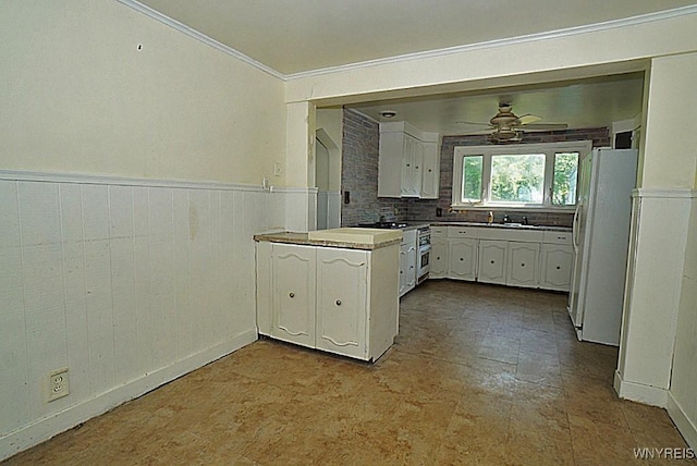 2927 S Ave, Niagara Falls, NY 14305 - kitchen featuring freestanding refrigerator, white cabinets, wainscoting, ornamental molding, and high end stove