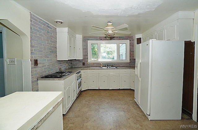 2927 S Ave, Niagara Falls, NY 14305 - kitchen featuring white refrigerator with ice dispenser, gas cooktop, white cabinets, ceiling fan, and oven