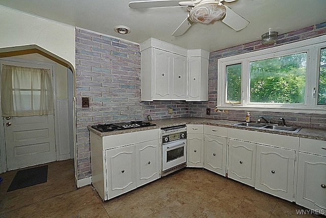 2927 S Ave, Niagara Falls, NY 14305 - kitchen featuring oven, a sink, white cabinetry, and plenty of natural light