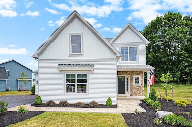 96 Chase Meadow Trl, Mendon, NY 14472 - view of front facade with board and batten siding, a front yard, and stone siding