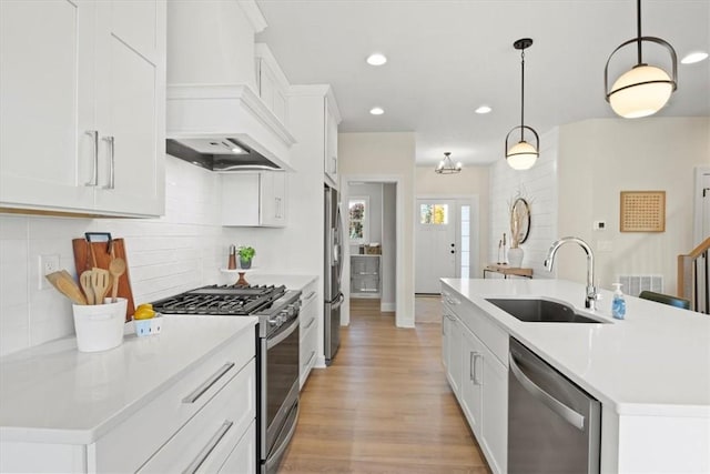 96 Chase Meadow Trl, Mendon, NY 14472 - kitchen with stainless steel appliances, a sink, premium range hood, light wood-style flooring, and an island with sink