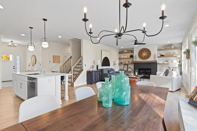 96 Chase Meadow Trl, Mendon, NY 14472 - dining room featuring a glass covered fireplace, stairs, recessed lighting, a chandelier, and light wood-style floors