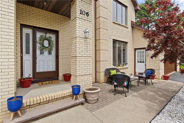 106 Shingle Landing Dr, Irondequoit, NY 14609 - doorway to property featuring brick siding, an outdoor living space, and a patio
