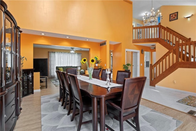 106 Shingle Landing Dr, Irondequoit, NY 14609 - dining room with a chandelier, stairway, a ceiling fan, a towering ceiling, and baseboards