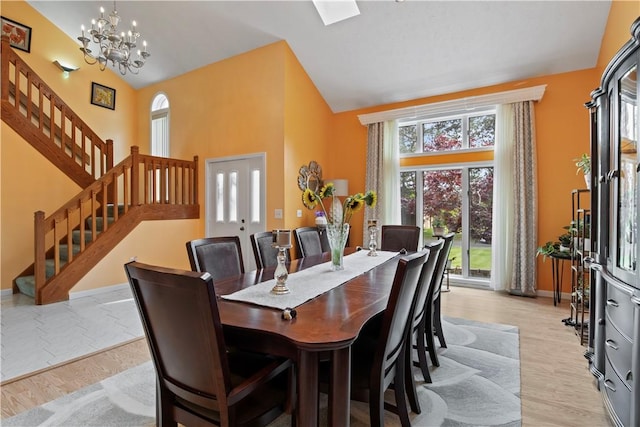 106 Shingle Landing Dr, Irondequoit, NY 14609 - dining area featuring high vaulted ceiling, stairs, plenty of natural light, a chandelier, and light wood-type flooring