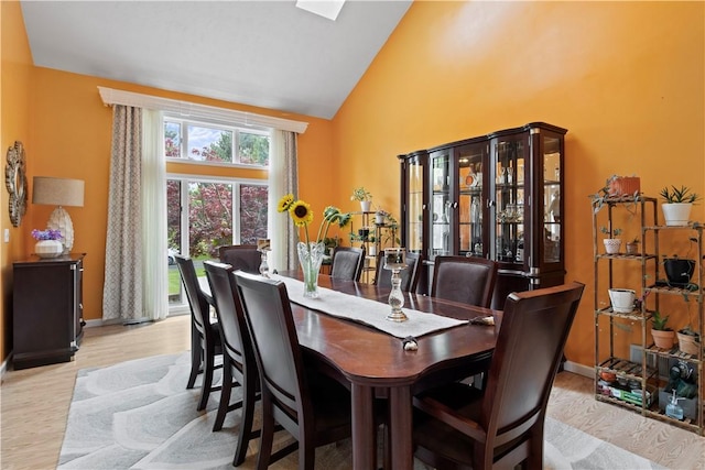 106 Shingle Landing Dr, Irondequoit, NY 14609 - dining area with high vaulted ceiling, baseboards, and light wood-style flooring