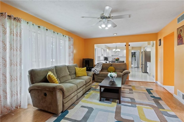 106 Shingle Landing Dr, Irondequoit, NY 14609 - living room with light wood-style floors, ceiling fan, and a chandelier