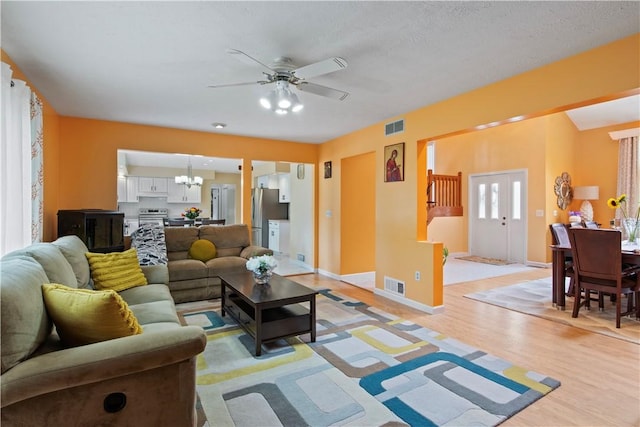 106 Shingle Landing Dr, Irondequoit, NY 14609 - living room with a chandelier, a ceiling fan, light wood finished floors, and baseboards