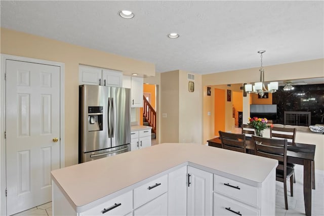 106 Shingle Landing Dr, Irondequoit, NY 14609 - kitchen featuring stainless steel refrigerator with ice dispenser, a chandelier, light countertops, open floor plan, and white cabinetry