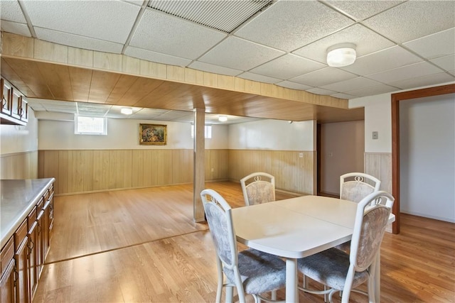 106 Shingle Landing Dr, Irondequoit, NY 14609 - dining area with light wood-type flooring, wainscoting, a paneled ceiling, and wooden walls