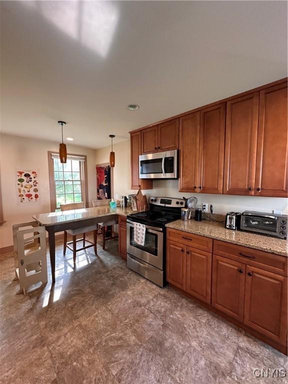 28 Payne St, Hamilton, NY 13346 - kitchen with stainless steel appliances, brown cabinets, pendant lighting, a peninsula, and light stone countertops