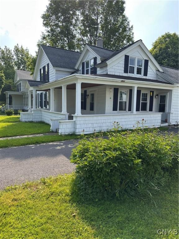 28 Payne St, Hamilton, NY 13346 - view of front facade with a chimney, a front yard, and covered porch