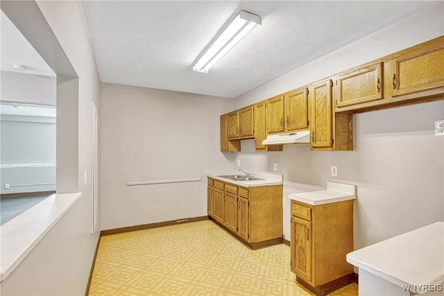639 17th St, Niagara Falls, NY 14301 - kitchen with under cabinet range hood, a sink, light countertops, and brown cabinetry