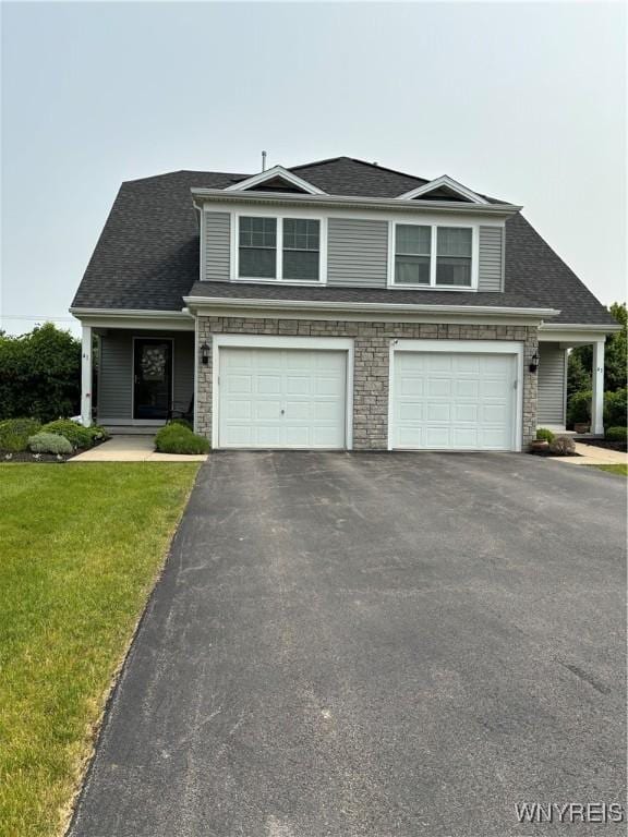 41 Brocton Dr, Lancaster, NY 14086 - view of front facade with driveway, a garage, a front yard, stone siding, and a shingled roof