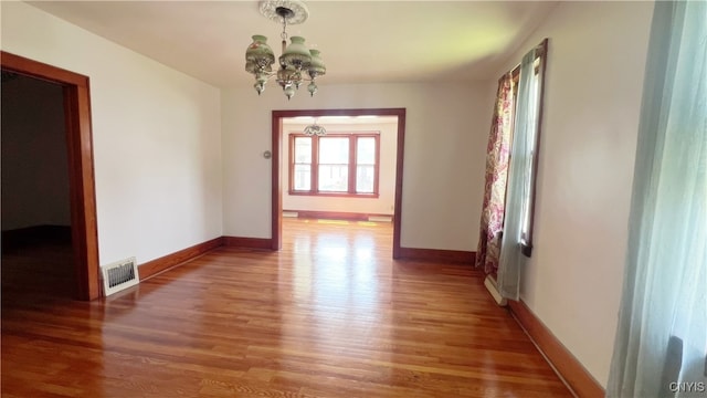 1324 Butternut St, Utica, NY 13502 - unfurnished dining area featuring a chandelier, wood finished floors, and baseboards