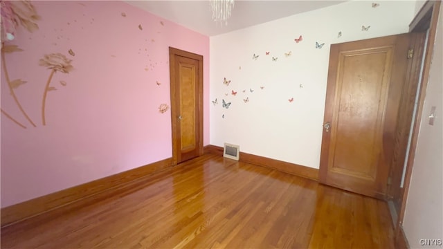 1324 Butternut St, Utica, NY 13502 - spare room featuring light wood finished floors, baseboards, and a chandelier