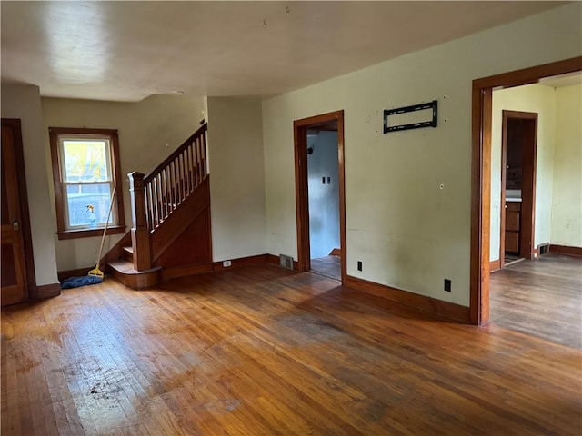 46 Kirby St, Bainbridge, NY 13733 - unfurnished living room with hardwood / wood-style floors, stairs, and baseboards