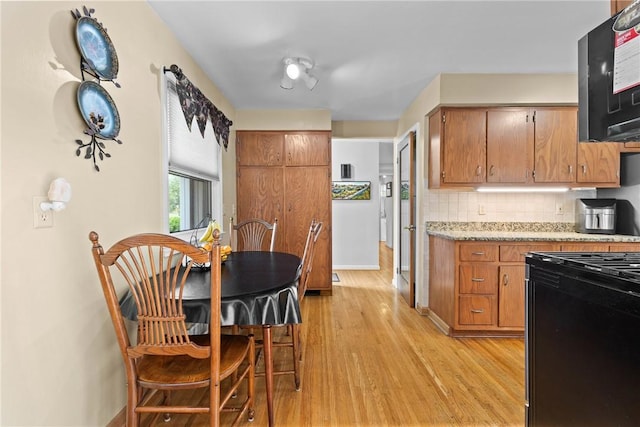 529 Backus Rd, Webster, NY 14580 - kitchen featuring gas range oven, light wood finished floors, backsplash, and brown cabinetry