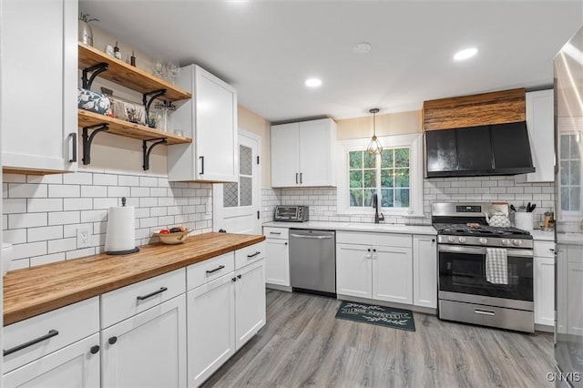 101 Doll Pkwy, Syracuse, NY 13214 - kitchen with stainless steel appliances, wood counters, a sink, white cabinetry, and tasteful backsplash