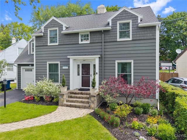 101 Doll Pkwy, Syracuse, NY 13214 - view of front of house with a chimney, roof with shingles, an attached garage, and driveway