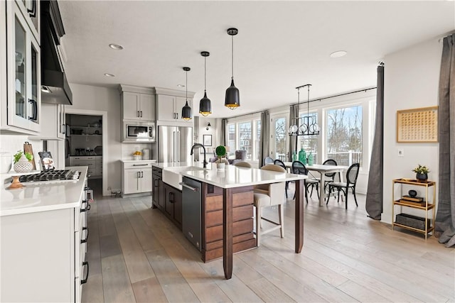 108 Chase Meadow Trl, Mendon, NY 14472 - kitchen with high quality appliances, a sink, light countertops, a kitchen breakfast bar, and tasteful backsplash