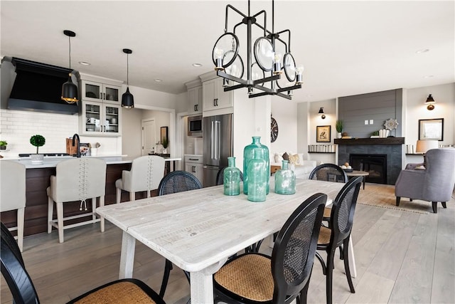 108 Chase Meadow Trl, Mendon, NY 14472 - dining space with a glass covered fireplace, light wood-style floors, a chandelier, and recessed lighting