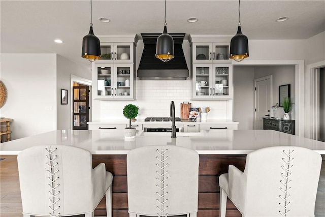108 Chase Meadow Trl, Mendon, NY 14472 - kitchen featuring custom exhaust hood, light countertops, an island with sink, tasteful backsplash, and pendant lighting