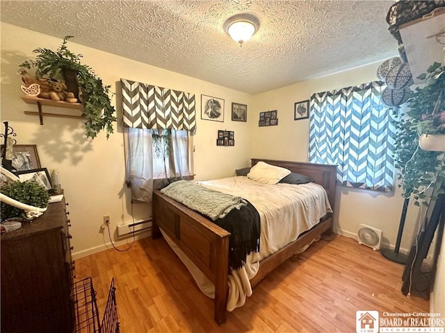 9983 Deer Creek Rd, Genesee, NY 14770 - bedroom with light wood-type flooring, a textured ceiling, a baseboard heating unit, and baseboards