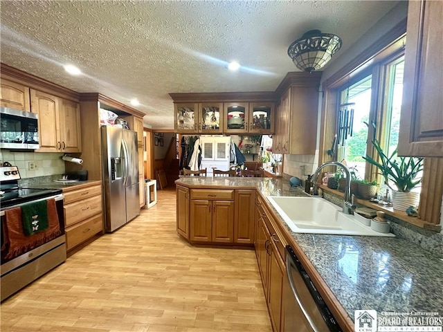 9983 Deer Creek Rd, Genesee, NY 14770 - kitchen featuring appliances with stainless steel finishes, a sink, a textured ceiling, a peninsula, and tasteful backsplash