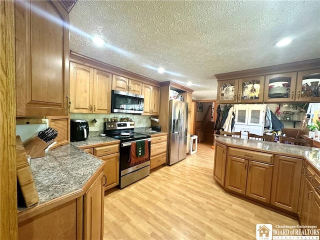 9983 Deer Creek Rd, Genesee, NY 14770 - kitchen featuring stainless steel appliances, light wood-type flooring, glass insert cabinets, a textured ceiling, and a peninsula